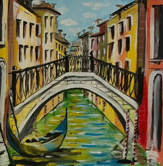 A gondola rests beneath an arched Venetian bridge, surrounded by warm yellow and terracotta buildings reflected in green canal water.