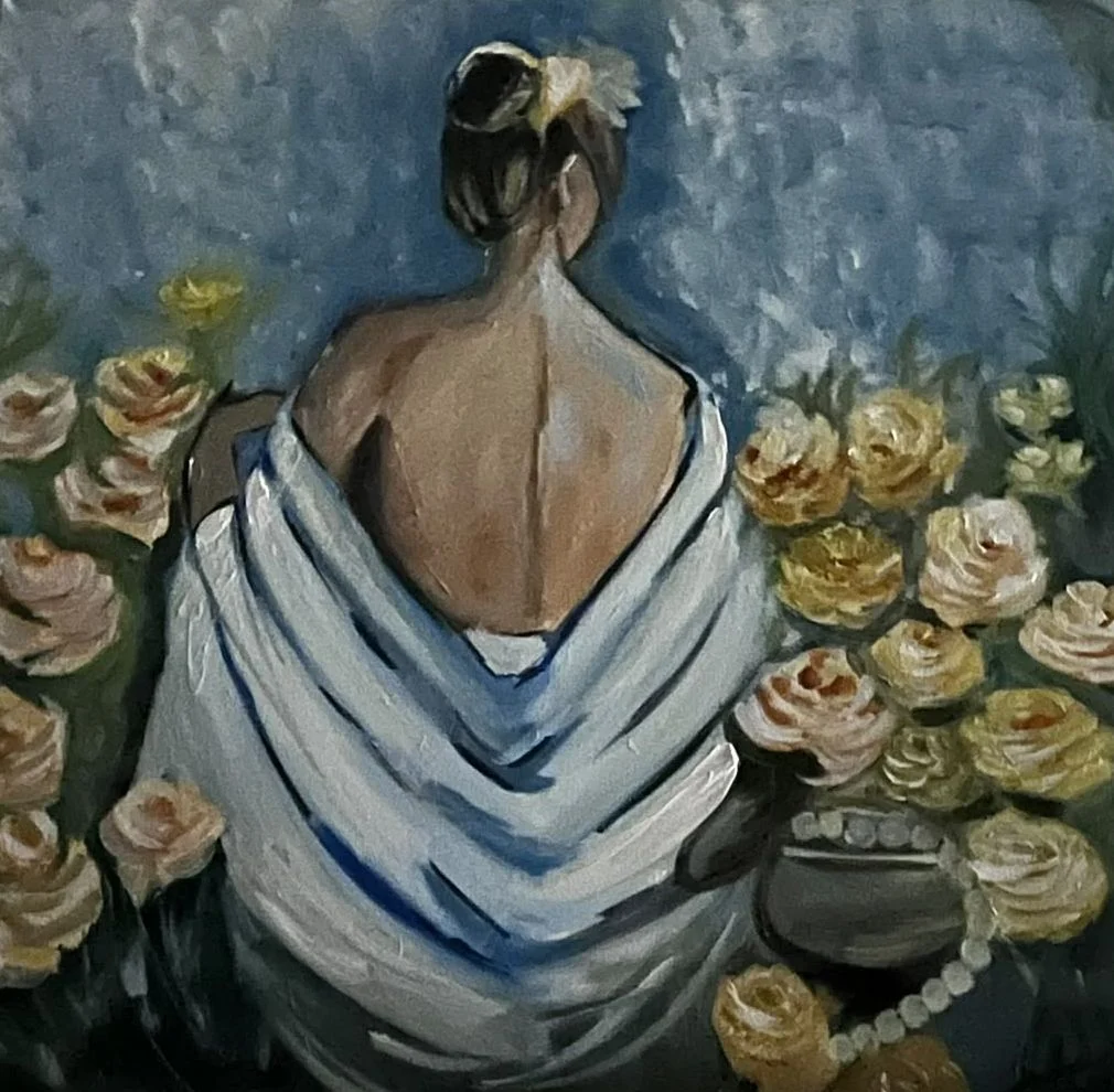 A woman with her back turned and dark hair in a bun wears a pale blue wrap among cream roses against a muted blue background.