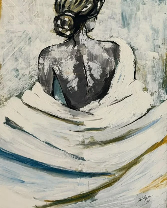 A woman seen from behind, her dark hair tied up, wrapped in sweeping ivory fabric with blue and ochre strokes.